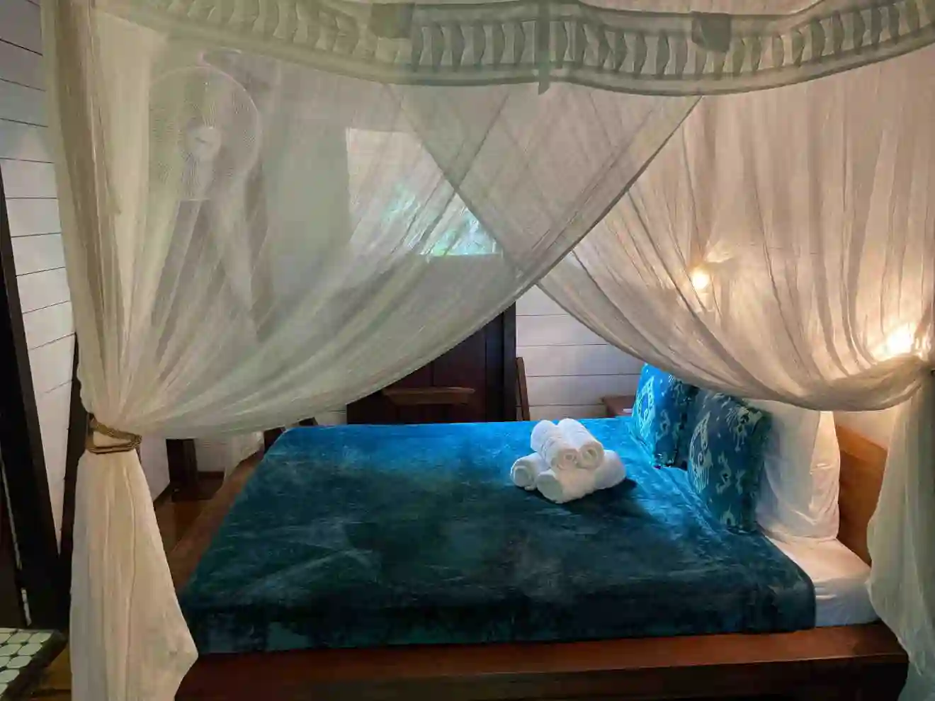 The four-poster bed, where your nights will be cooled by the air conditioning and fan, and where the mosquito net will protect you.