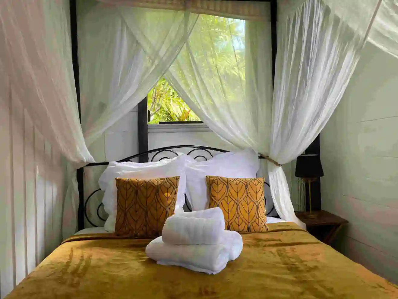 Small room with a 140cm bed, mosquito net, and air conditioning